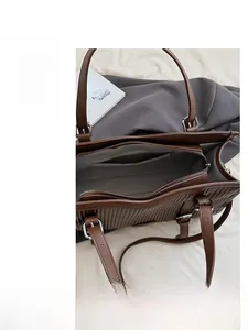 Detailed interior of dark brown leather tote with grey lining and zippered inner pocket