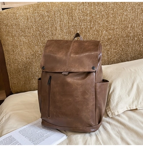 Brown vintage faux leather backpack with magnetic flap closure and front vertical zip pocket