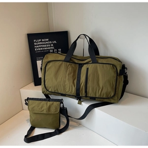 Detail of army green travel set featuring large duffel bag and mini crossbody on white steps