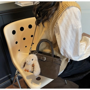 Deep brown crossbody bag with matte faux leather and a plush rabbit charm accessory
