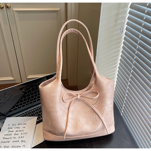 Detail of elegant pink tote bag featuring a decorative bow and GONGZHU embossed logo