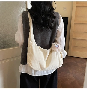 Detail of soft cream crescent crossbody bag with cute plush bunny charm and zip closure