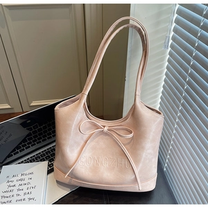 Close-up of pink leather tote bag with bow detail and embossed GONGZHU lettering