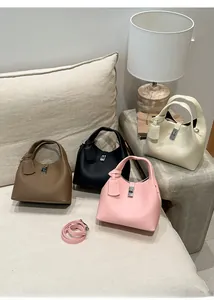 Litchi pattern leather bucket bags in brown black pink and white on a sofa scene