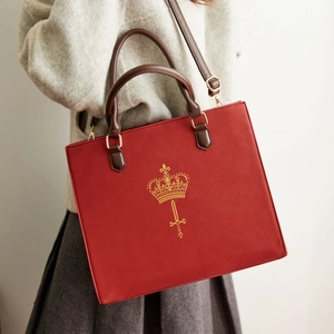 Red retro tote bag with golden crown emblem shown in a vintage fashion style outfit