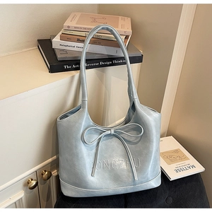 Detailed view of light blue tote bag with ribbon bow and GONGZHU embossed lettering