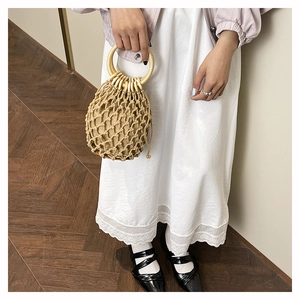 Détail du sac à main en maille de corde tissée main avec poignées rondes en bois
