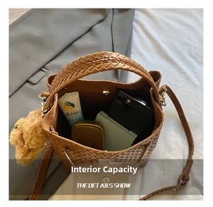 Spacious interior of brown woven bucket bag showing capacity for phone and cosmetics