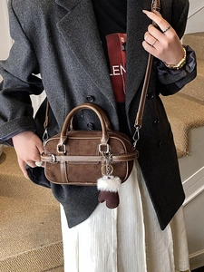 Vintage brown bowling bag in suede and leather, styled with a grey blazer and plush charm
