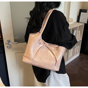 Détail du nœud élégant et du lettrage ONGZHU embossé sur le sac cabas en similicuir rose