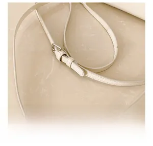 Macro shot of adjustable white leather strap with polished silver metal buckle detail