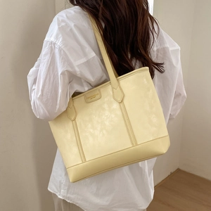 Gros plan du sac cabas en cuir jaune crème avec bandoulière et étiquette de mode