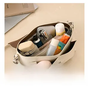 Top view of large capacity crossbody bag interior showing phone, umbrella and cosmetics
