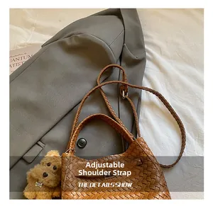 Detail of a brown woven bucket bag with adjustable strap and plush dog charm