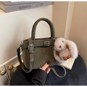 Détail du sac à main vert olive avec charme lapin en peluche et boucle rétro