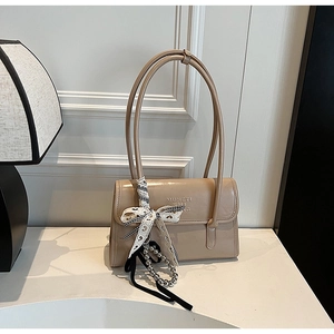 Detail of beige long-handle shoulder bag with ribbon bow and silver bead chain