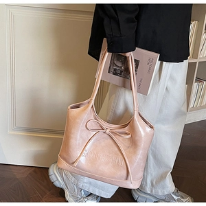 Close-up of pink hobo bag with large bow detail and GONGZHU embossed text design