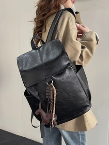 Minimalist black PU leather backpack for women with side pockets shown on a model
