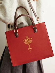 Vintage burgundy tote bag with gold crown logo and brown handles shown on a model