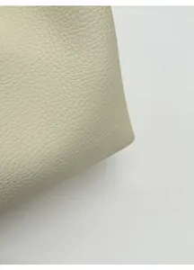 Detail of soft cream lychee grain leather showing flexible structure and premium texture
