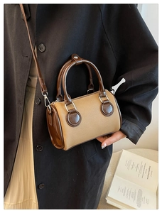 Detalle de bolso boston vintage de lona con asas de cuero marrón y correa ajustable