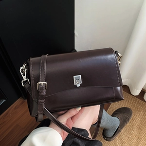 Detailed view of vintage dark brown leather crossbody bag with silver buckle and adjustable strap