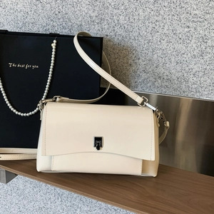 Detailed macro view of the cream leather flap bag with silver-black metal twist lock