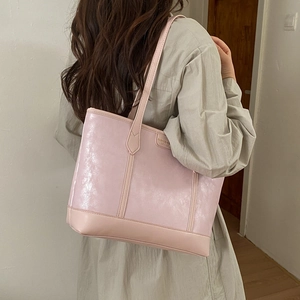 Détail d'un cabas rose clair en similicuir avec texture froissée brillante et coutures