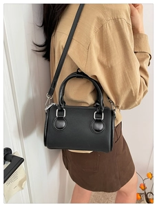 Modelo con mini bolso Boston negro con herrajes plateados y correa ajustable