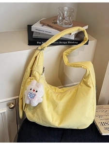Minimalist soft yellow dumpling shoulder bag with plush bunny charm and wide strap