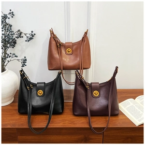 Detailed trio of vintage leather bucket bags in brown, black and purple with gold clasps