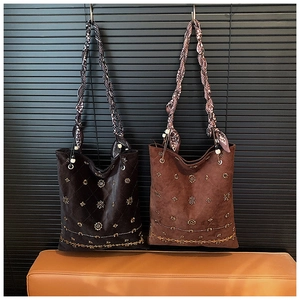 Detail of bohemian suede tote bag with intricate gold studs and floral embroidery
