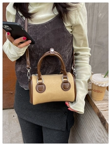 Detalle del bolso tipo almohada de lona vintage con ribetes de cuero marrón y herrajes