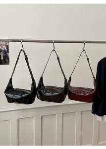 Three glossy patent leather crescent bags in black, dark brown, and burgundy colors