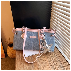 Detalle de bolso bowling de mezclilla azul con ribete rosa y colgante de estrella