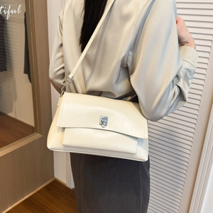 Off-white leather shoulder bag detail with silver square twist lock and model styling