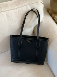 Grand sac cabas noir en cuir minimaliste avec lettrage doré sur canapé chic