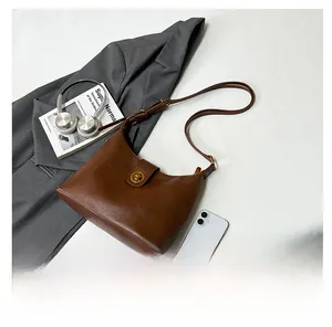 Detailed view of brown hobo bag with vintage bronze twist lock and adjustable strap