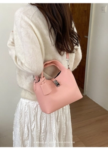 Pale pink bucket bag with lychee texture and silver twist lock shown in lifestyle view