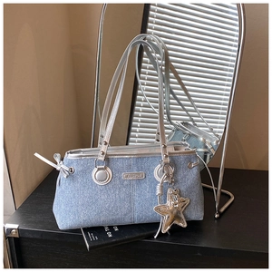 Detalle del bolso bowling de mezclilla azul claro con ribete plateado y colgante estrella