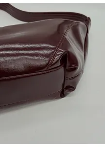 Close-up of the reinforced bottom with double stitching on the burgundy leather tote bag