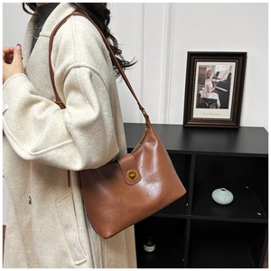 Detail of caramel leather shoulder bag with vintage gold-tone twist-lock closure