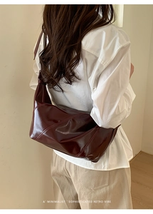 Close-up of deep burgundy glossy leather hobo bag with vintage pleated detail and shine