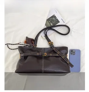 Detail showing deep brown leather texture with contrast white stitching and metal buckle