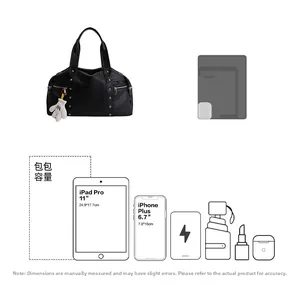 Detail view of black tote bag capacity with cartoon hand charm and side zipper pockets