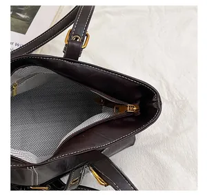 Detail view of large brown vintage tote bag with zipper closure and herringbone lining