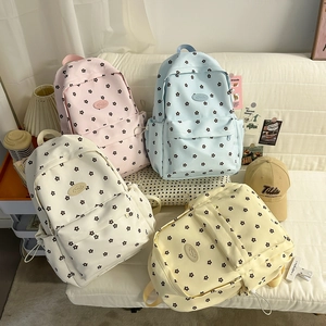 Group display of floral canvas backpacks in pink, blue, beige, and yellow colors
