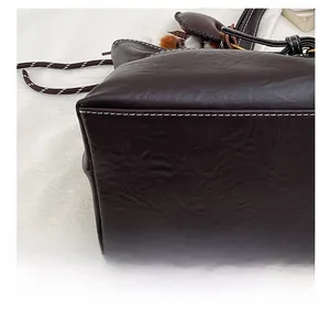 Detail shot of white contrast stitching on deep brown lychee grain leather tote bag