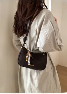 Gros plan du sac à bandoulière rétro en cuir avec perles en bois et détails en laiton