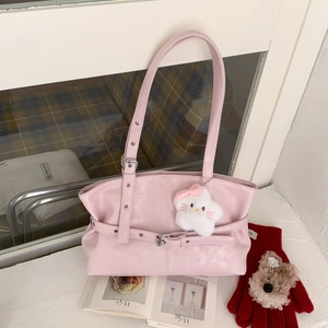 Close-up of pink leather tote bag with silver metal buckles and a star plush charm